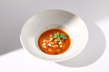 Italian Style Tomato Seafood Soup with a Basil Garnish, Served in a White Bowl, Perfect for Mediterranean Cuisine Promotions