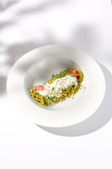 Spaghetti with Pesto Sauce and Stracciatella Cheese, Shadow of a Leaf on White, Ideal for Seasonal Menu Features