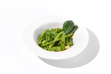 Fresh green vegetable garnish featuring asparagus, zucchini, and edamame beans on isolated white background