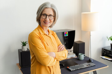 Confident smiling business woman, manager, CEO holding arms crossed standing in modern office....