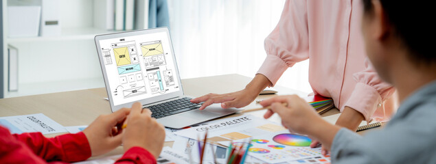 Cropped image of interior designer team discuss the material color while laptop displayed website...