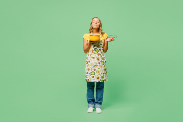 Full body young happy housewife housekeeper chef cook baker woman wear apron yellow t-shirt hold in...