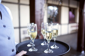 Several glasses filled with champagne are kept on a tray.
