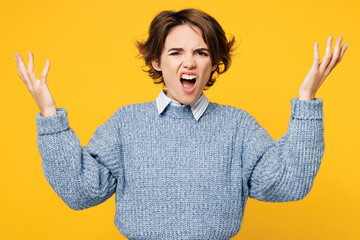 Young angry sad mad woman she wears grey knitted sweater shirt casual look camera spread hands clothes spread hands scream shout isolated on plain yellow background studio portrait. Lifestyle concept.