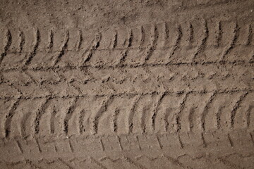 Tire tread prints on the ground. tire tracks. Tire tracks on a sandy road. Car tread prints on the sand. Footprint and traces of an off-road car tires in the mud. tire prints in the snow.