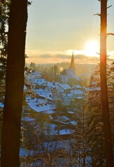Idyllic town in winter season with snow covered houses in the eifel mountains at sunset, Zingsheim,...