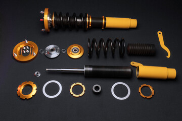 suspension tuning, coilovers, shock absorbers and front springs in yellow and gold colors for a sports drift car on a dark background	