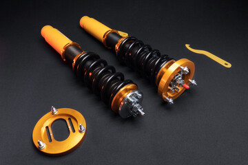 suspension tuning, coilovers, shock absorbers and front springs in yellow and gold colors for a sports drift car on a dark background	