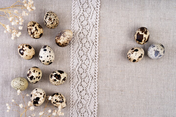 Composition with Easter eggs on textile linen fabric. Texture of linen fabric with quail eggs.