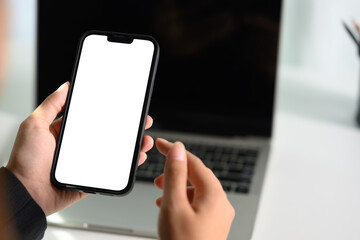Closeup of female hands holding smartphone with white screen for your text message