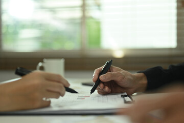 Professional businesspeople discussing and working with financial graph chart report at desk