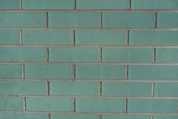 Front view of blue green brick wall with light grey mortar joints