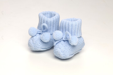 baby booties, for newborns, the first shoes with delicate feet on a light background