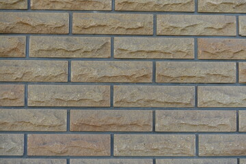 Front view of beige brick veneer wall with grey mortar joints