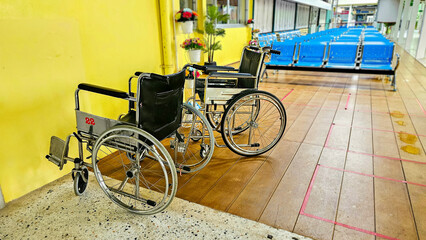 Empty wheelchairs service in hospital. Empty modern wheelchair in hospital room. Empty waiting room, with sitting chairs and two wheelchair for patients.