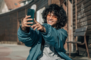 young vintage man on the street with mobile phone making a selfie or live video