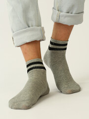 gray socks with black stripes on human foot close up photo on white background