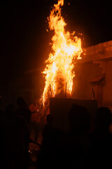Fototapeta na wymiar une case africaine en flamme dans un village lors d'une commémoration 
