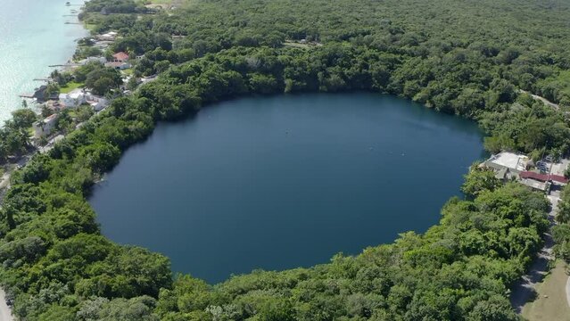 Aerial view of the Cenote in the Bacalar Lake, boats are sailig around it