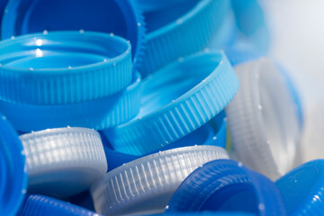 close-up of blue and gray plastic lids for recycling on the glass. washing and drying water bottle caps. waste management and recycling to Plastic packaging manufacturer	