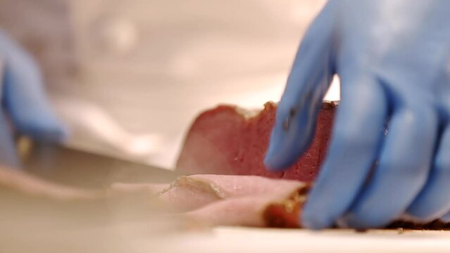 ローストビーフの牛肉の塊を薄く切り分けるシェフの手元　肉料理・レストラン・調理