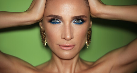 Fashion beauty portrait of a mature woman with smokey eyes make up wearing golded jewerlys posing...