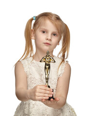 Blonde baby 6 years old, in a white dress shows a oscar