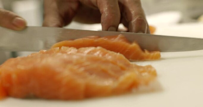 鮭サーモンをナイフで切り分ける　魚・料理・レストラン・手元