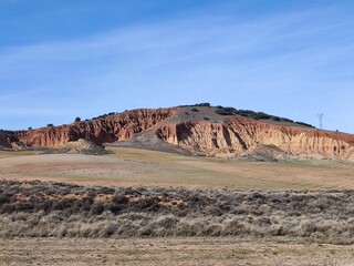 Paisaje con una peque&ntilde;a monta&ntilde;a de fondo y venados en pasto verde comiendo en invierno. 