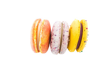 Sweet yummy macarons isolated on white background. Brightly colorful stacked macaroons. Three tasty multi-colored orange, pink and yellow macaroons. French pastry made from egg whites.