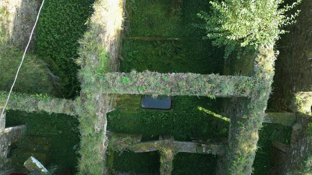 Top down drone footage of the nature taking over a dilapidated remains of a structure in Zas, Spain