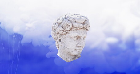 Image of clouds and head of sculpture on blue background