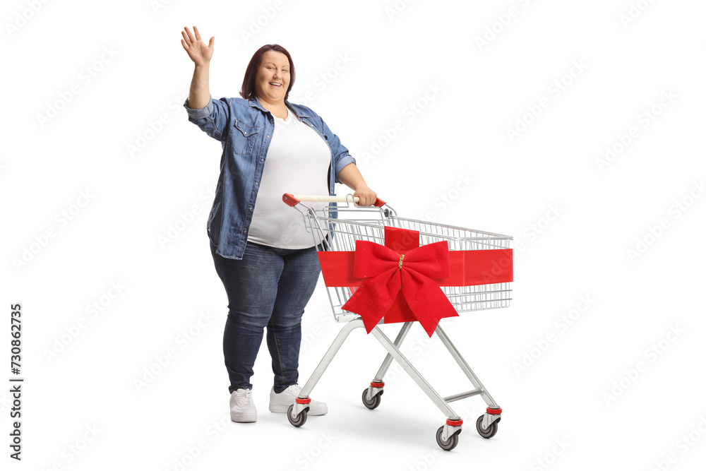 Canvas Prints Corpulent woman waving and standing with a shopping cart