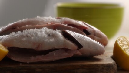 Obraz premium Seasoning Fish with Salt and Lemon for Cooking. Close-up, shallow dof.