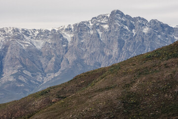 Obraz premium Snow-capped peaks of Breede Valley's distant mountains on a chilly day in Worcester, South Africa