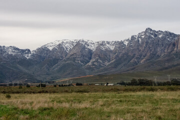 Fototapeta na wymiar Snow-capped peaks of Breede Valley's distant mountains on a chilly day in Worcester, South Africa