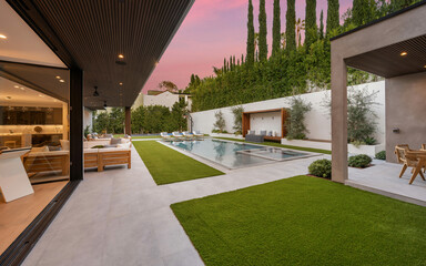 Outdoor patio adjacent to a sparkling pool in the backyard