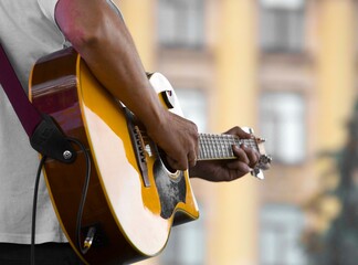 close-up of the hands of a musician playing an acoustic guitar