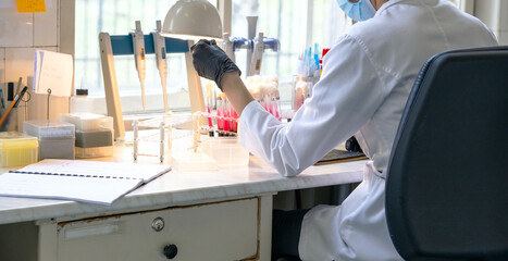 Fototapeta premium Technician analyzing biochemical samples in chemical or microbiology laboratory for medicine. Authentic retro medical research laboratory.