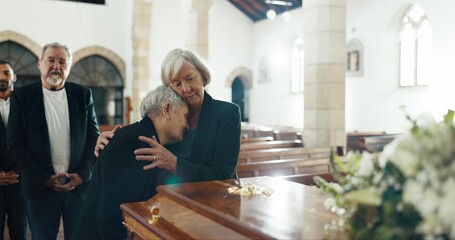 Senior women, hug and funeral in church for comfort, support and care with crying, sad and religion. Family, friends and embrace for death, loss and console with love, empathy and faith by coffin - obrazy, fototapety, plakaty