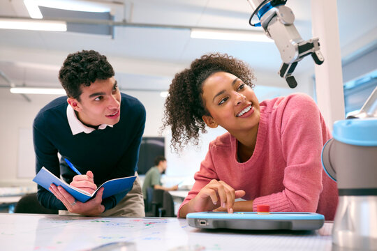 Male And Female College Or University Engineering Students In Robotics Class Working Together