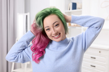 Trendy hairstyle. Young woman with colorful dyed hair at home © New Africa