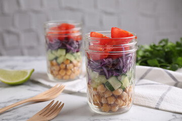 Healthy salad in glass jars on marble table