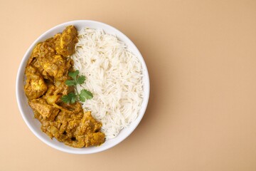 Delicious chicken curry with rice on beige background, top view. Space for text