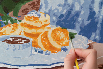 A photo of a picture that is colored by numbers in the process of coloring with a brush