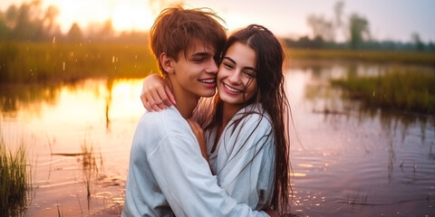 Romantic couple embracing in wild, rainy marsh with sunlight.
