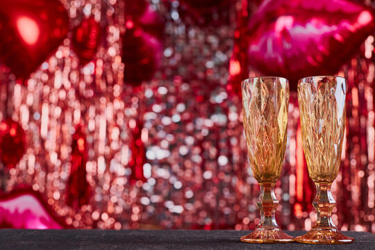 Festive background for valentine's day with copy space. Festive red bokeh of tinsel, balloons and romantic decoration, unfocused