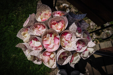 Valmiera, Latvia - July 7, 2023 - Bouquets of pink and white rose petals in paper cones...