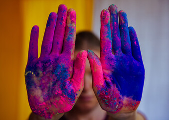 Women's palms covered with bright dry Holi paint. Hands covered in dry paint