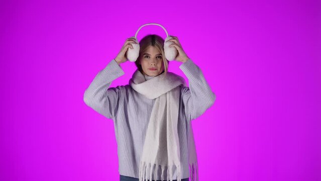 Piekna kobieta zakłada pluszowe ocieplacze na uszy